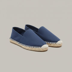 Blue espadrilles on a wooden stool with a patterned rug in the background