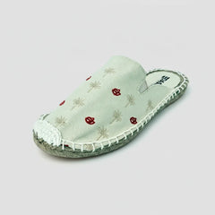 Light green slipper with floral patterns on a white background