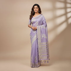 Purple and beige scarf with floral patterns on a textured surface with leaves and a candle.