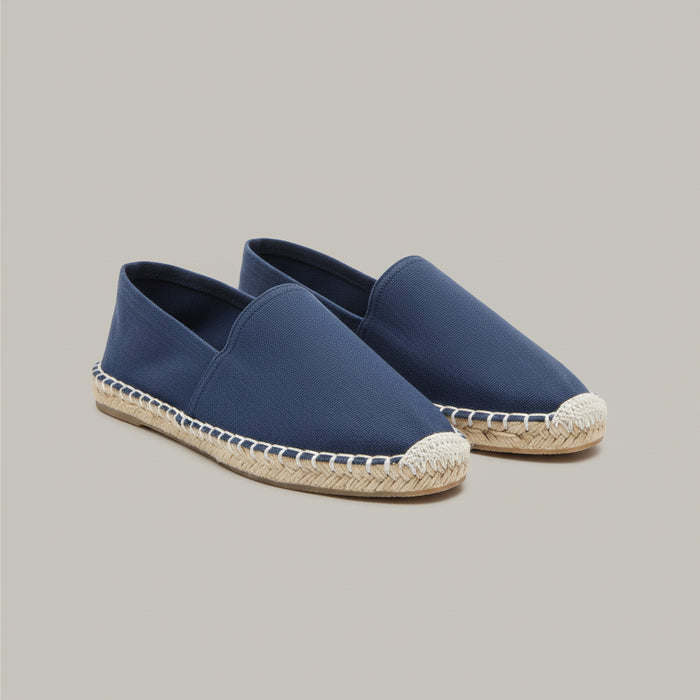 Blue espadrilles on a wooden stool with a patterned rug in the background