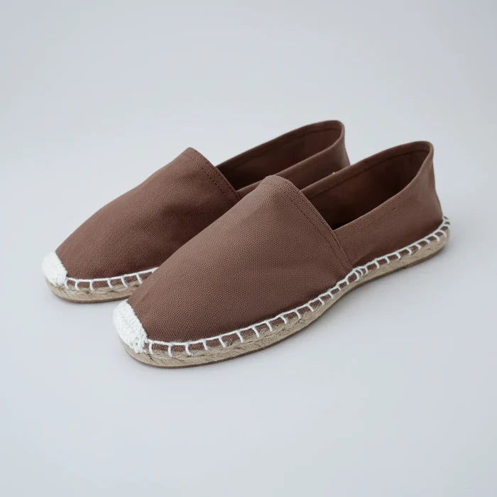 Pair of brown espadrilles with white sole on a white background