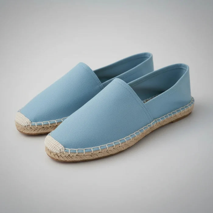 Pair of light blue espadrilles on a white background