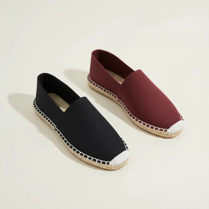 Black espadrille shoe with white sole on a white background