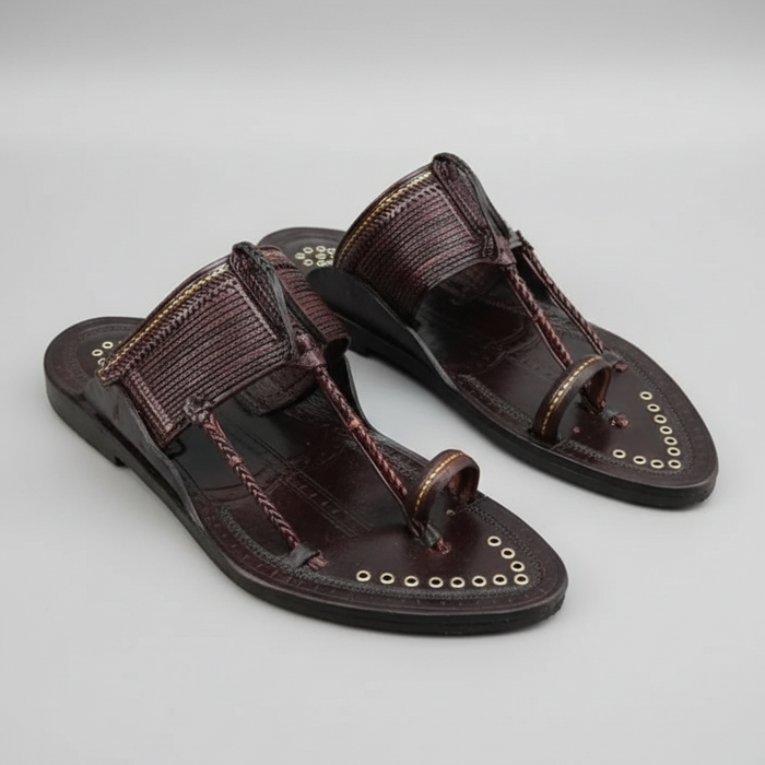 Pair of brown sandals with decorative straps on a gray background