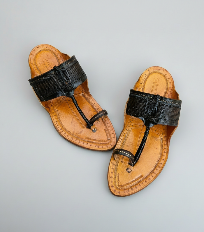 Pair of tan sandals with black straps on a gray background