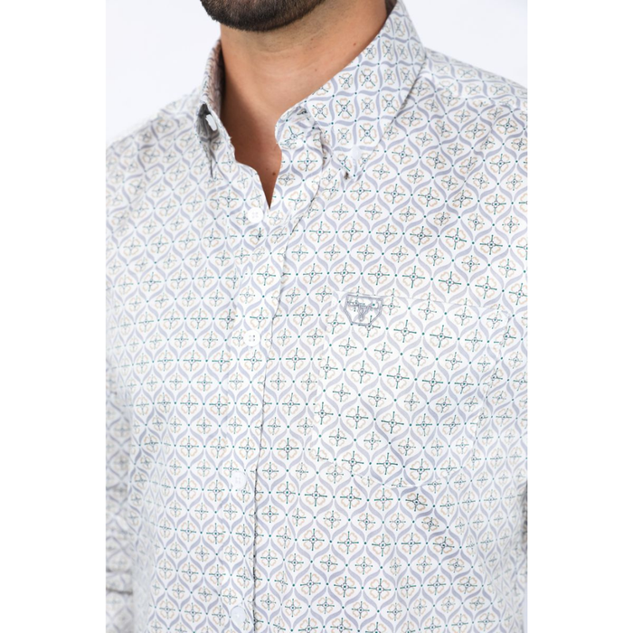 Man wearing a light gray with green accents long sleeve geometric print button-down shirt paired with jeans, modern men's fashion look0- front view- close up of collar and button view