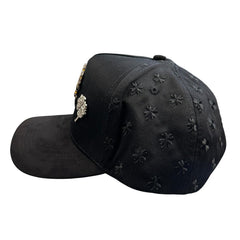 Side view of black snapback hat featuring tonal embroidered clover pattern